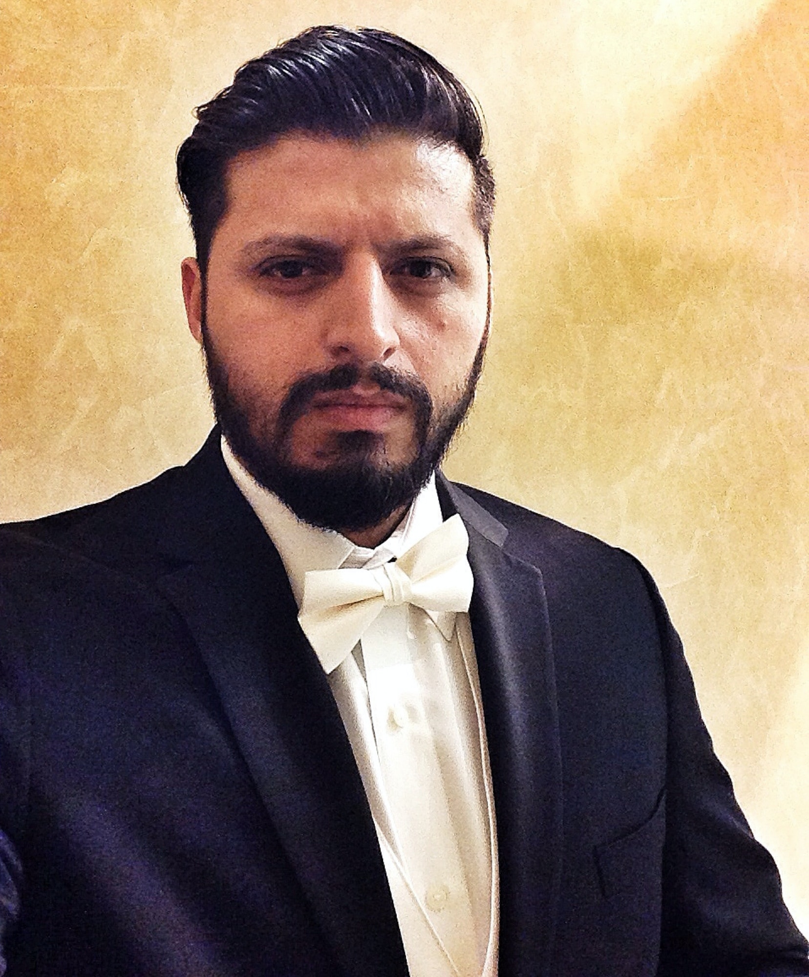 Selfie portrait of Hispanic/ latino man with beard wearing a suit.